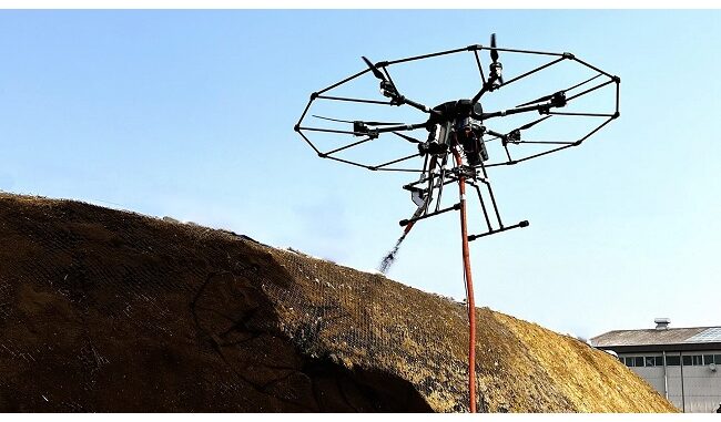 開発した植生基材吹付工法を行う法面吹付用有線給電ドローン